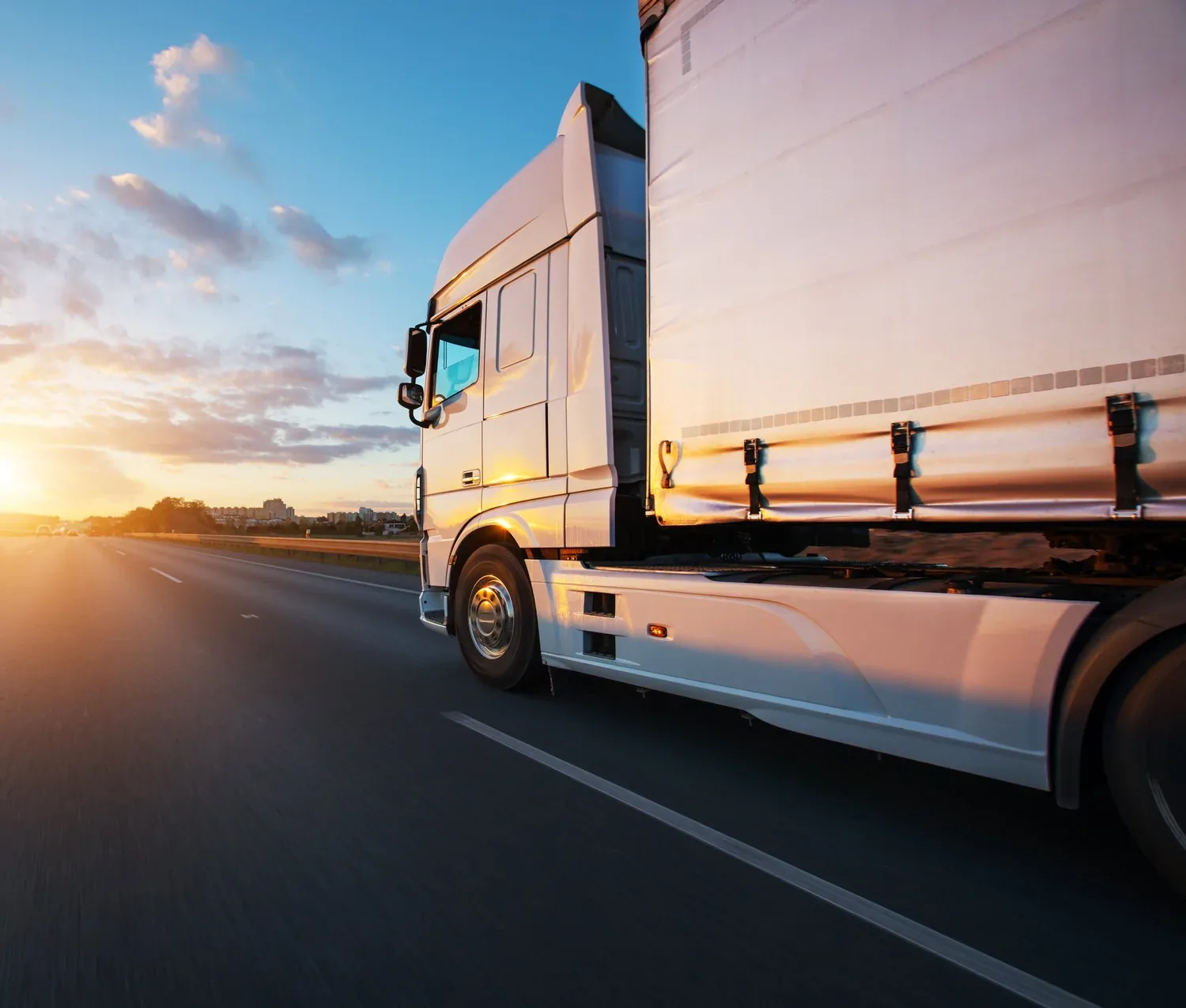 A transport truck on the highway at sunset